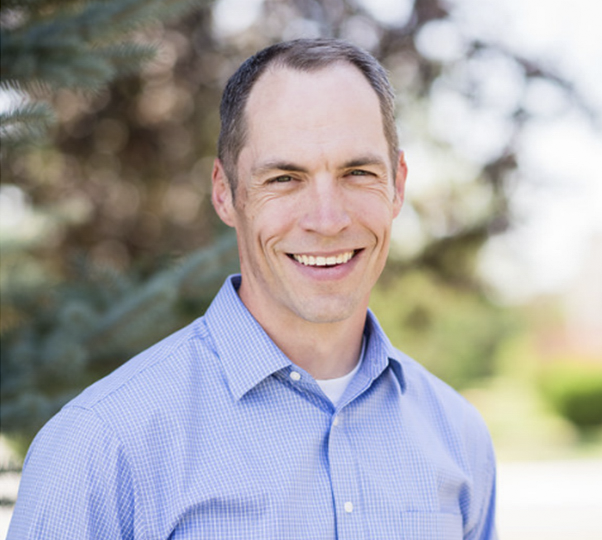 smiling outdoor portrait of Dr.Liljenquist, white man with very short dark hair
